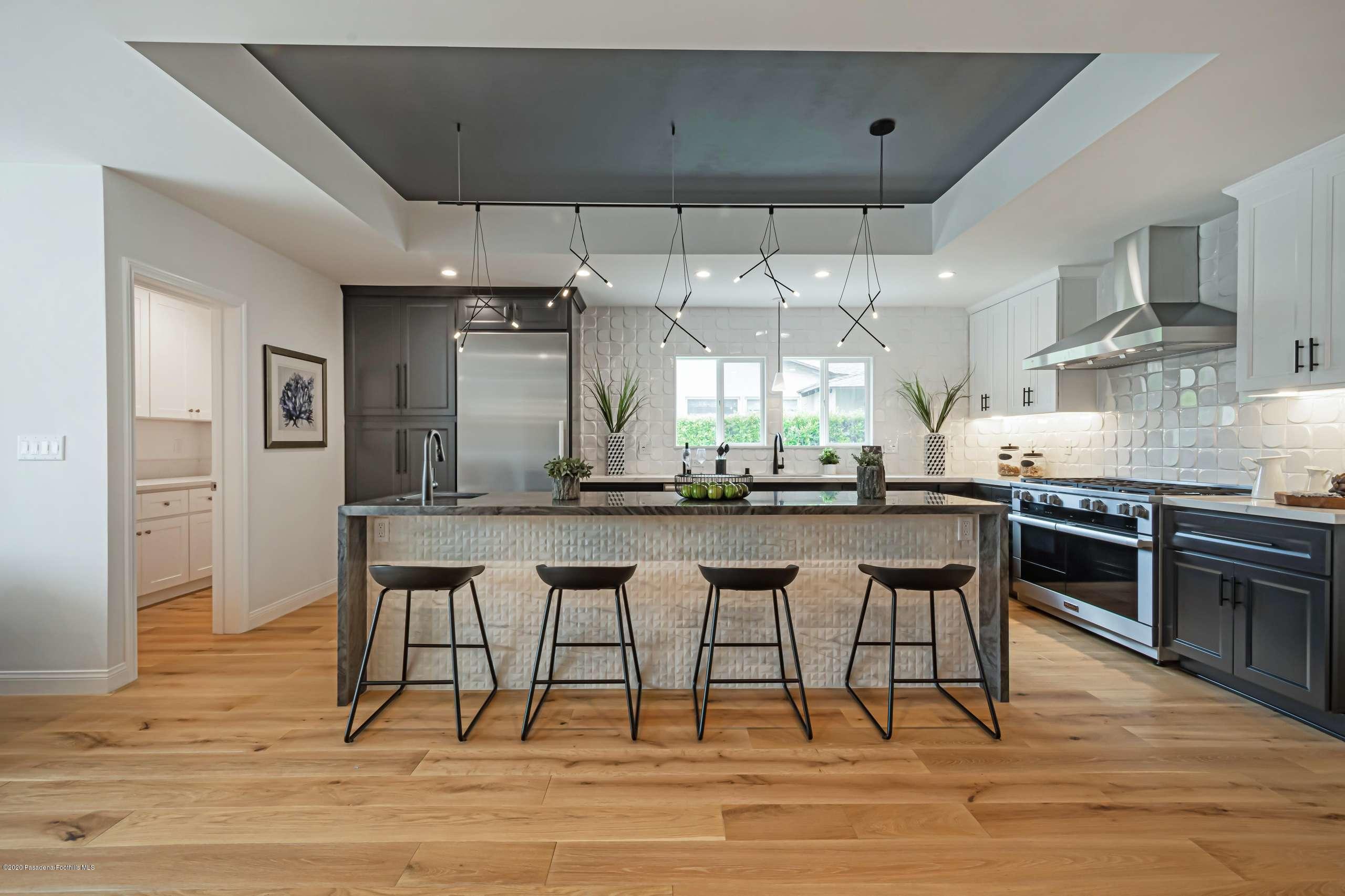 3590 Fairmeade Road Pasadena, CA 91107 - Photo 19 of 45 a kitchen with stainless steel appliances kitchen island granite countertop a table chairs sink and cabinets