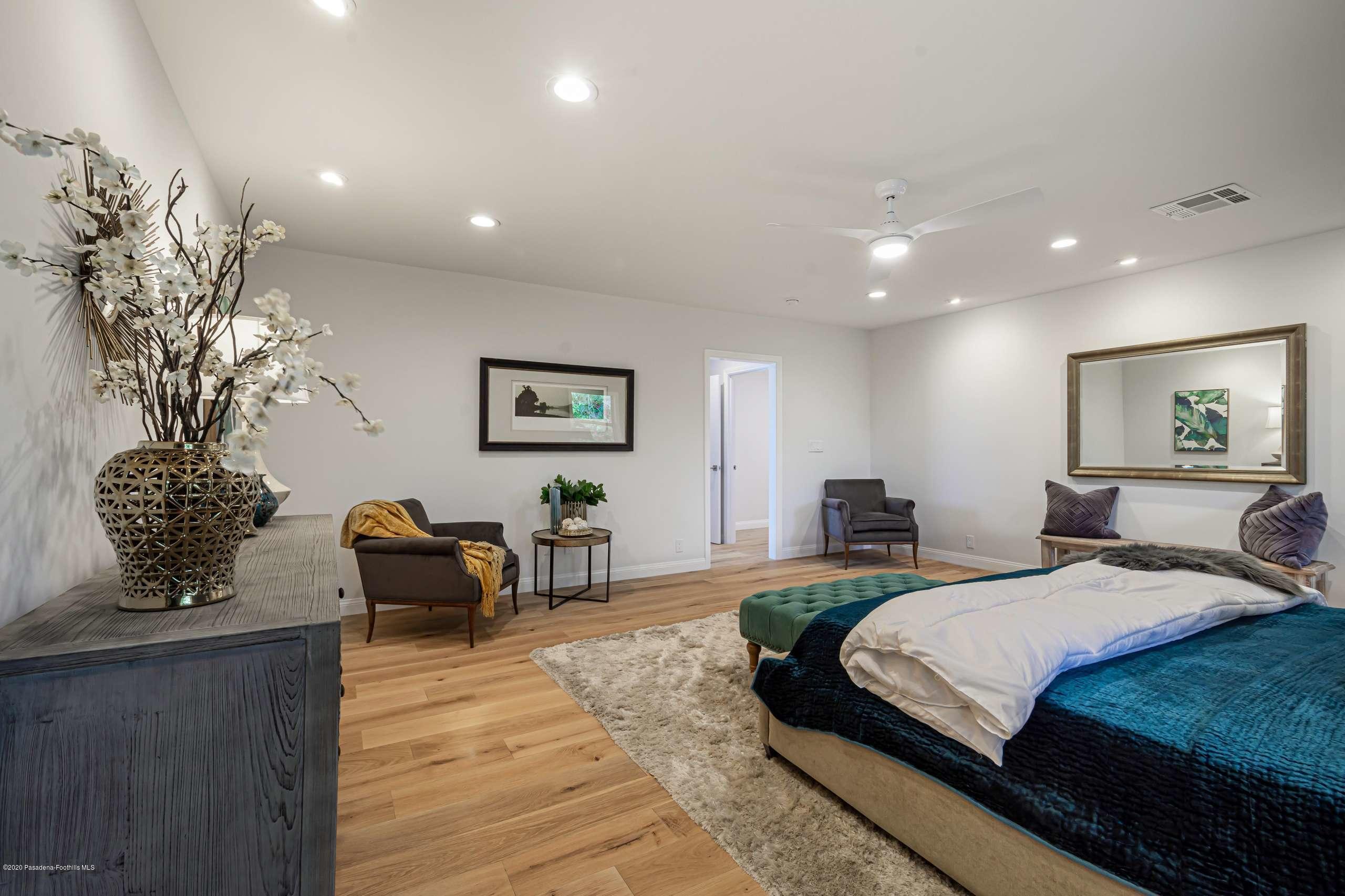 3590 Fairmeade Road Pasadena, CA 91107 - Photo 35 of 45 a spacious bedroom with a large bed and a chandelier
