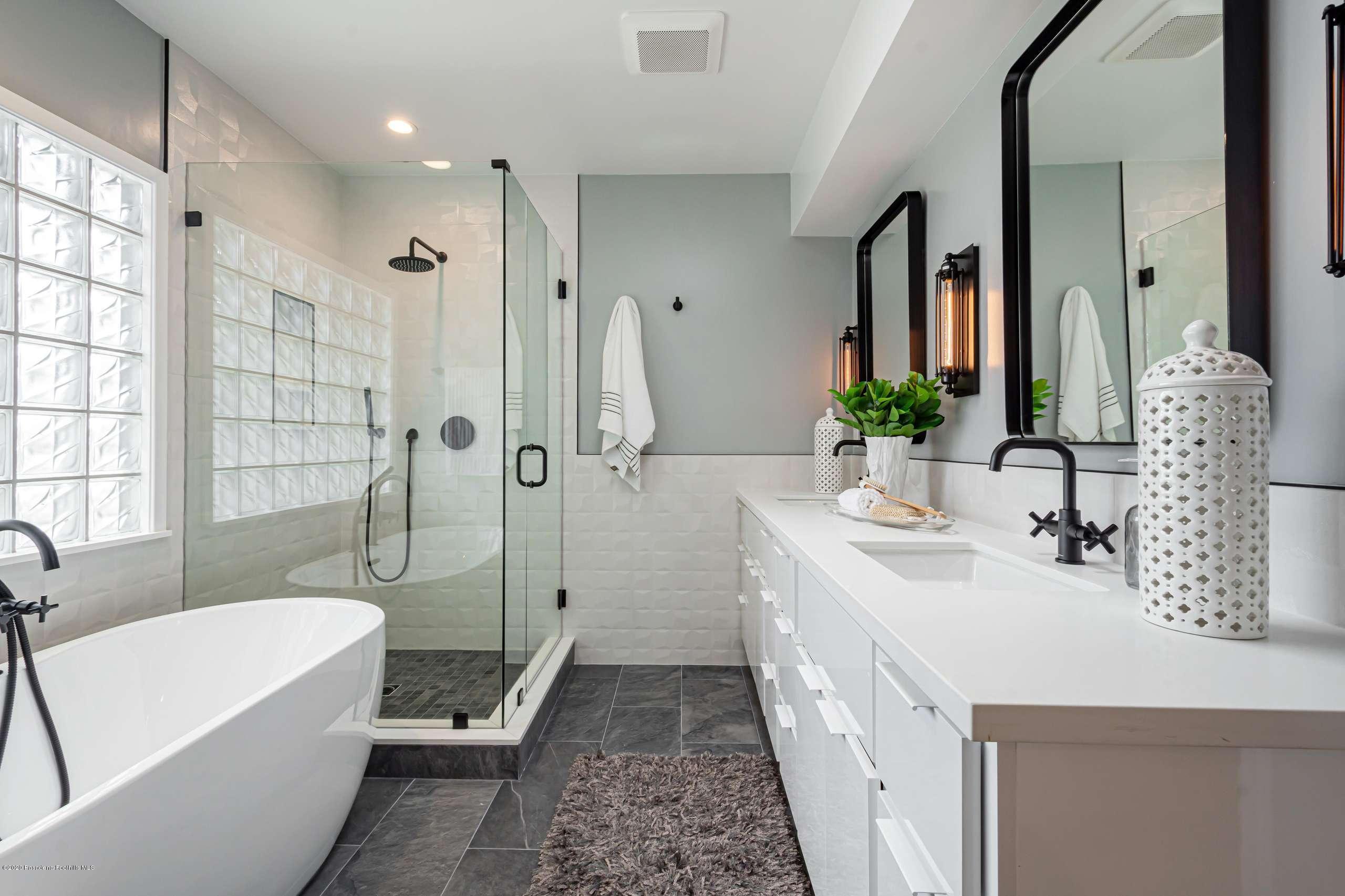 3590 Fairmeade Road Pasadena, CA 91107 - Photo 37 of 45 a bathroom with a double vanity sink a large mirror a bathtub and shower