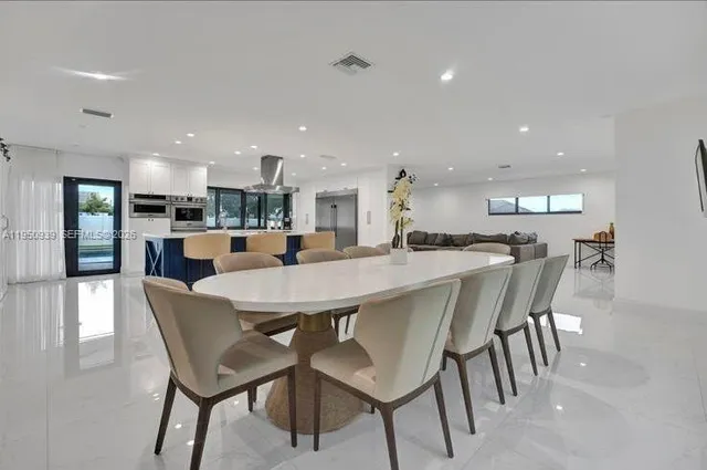 a dining area with a table chairs and a kitchen view