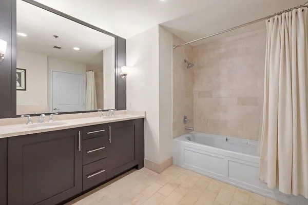 a bathroom with a tub sink shower and mirror