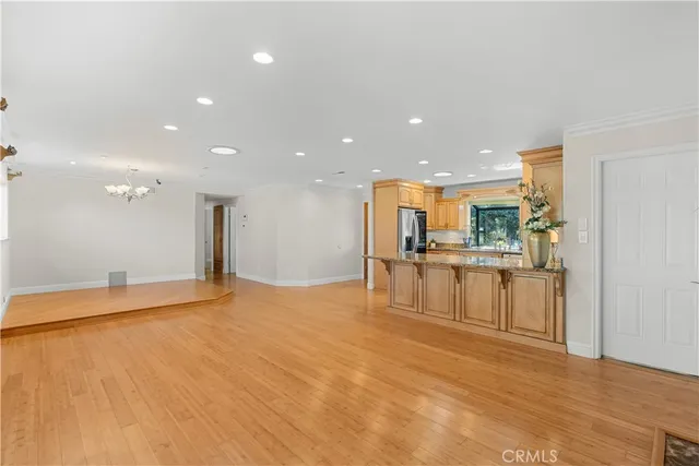 a view of a kitchen with kitchen island a sink stainless steel appliances and cabinets