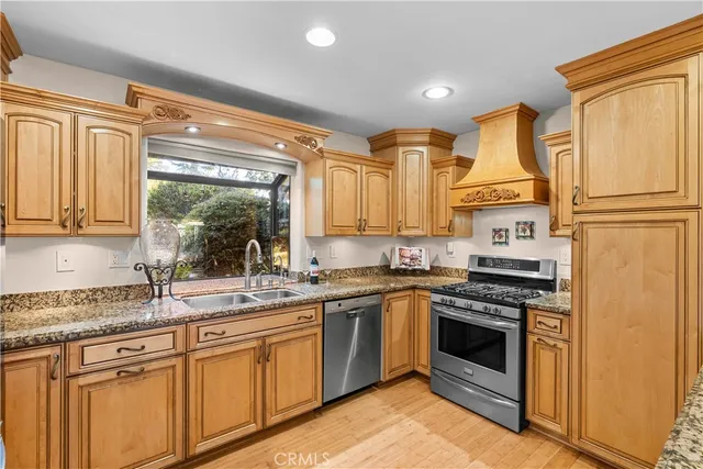 a kitchen with stainless steel appliances granite countertop a stove sink and cabinets