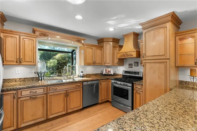 a kitchen with kitchen island granite countertop a sink stainless steel appliances and cabinets