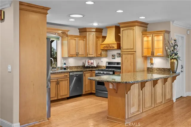 a kitchen with stainless steel appliances granite countertop a stove a sink and a refrigerator