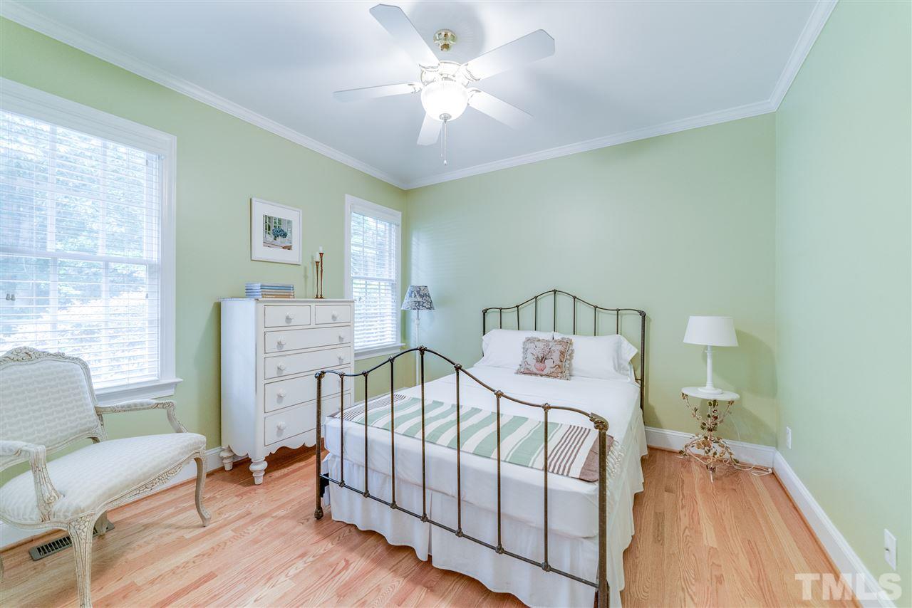 5233 Wildmarsh Drive Raleigh, NC 27613 - Photo 13 of 25 a bedroom with a bed and a chandelier