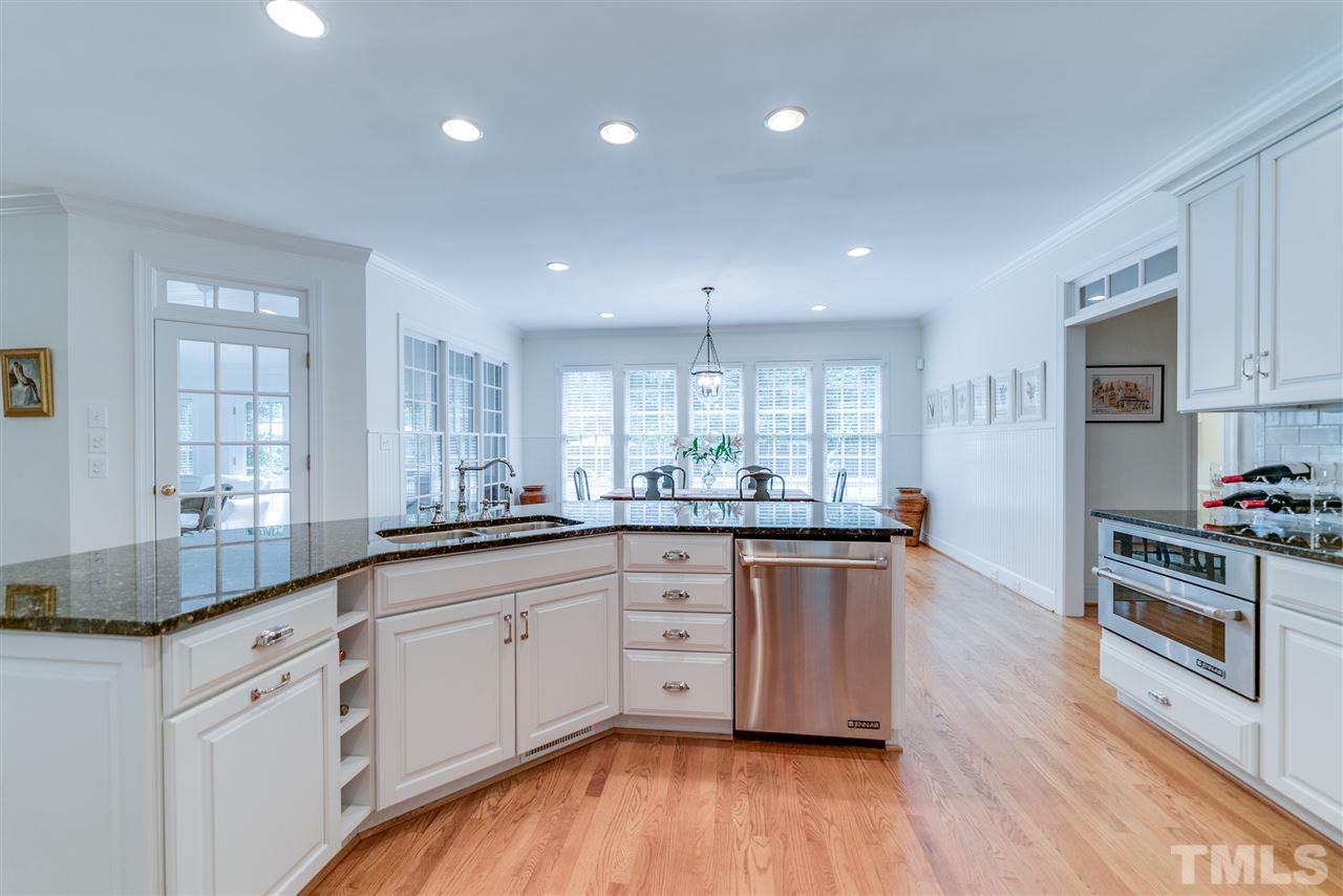 5233 Wildmarsh Drive Raleigh, NC 27613 - Photo 6 of 25 a kitchen with granite countertop white cabinets and wooden floor