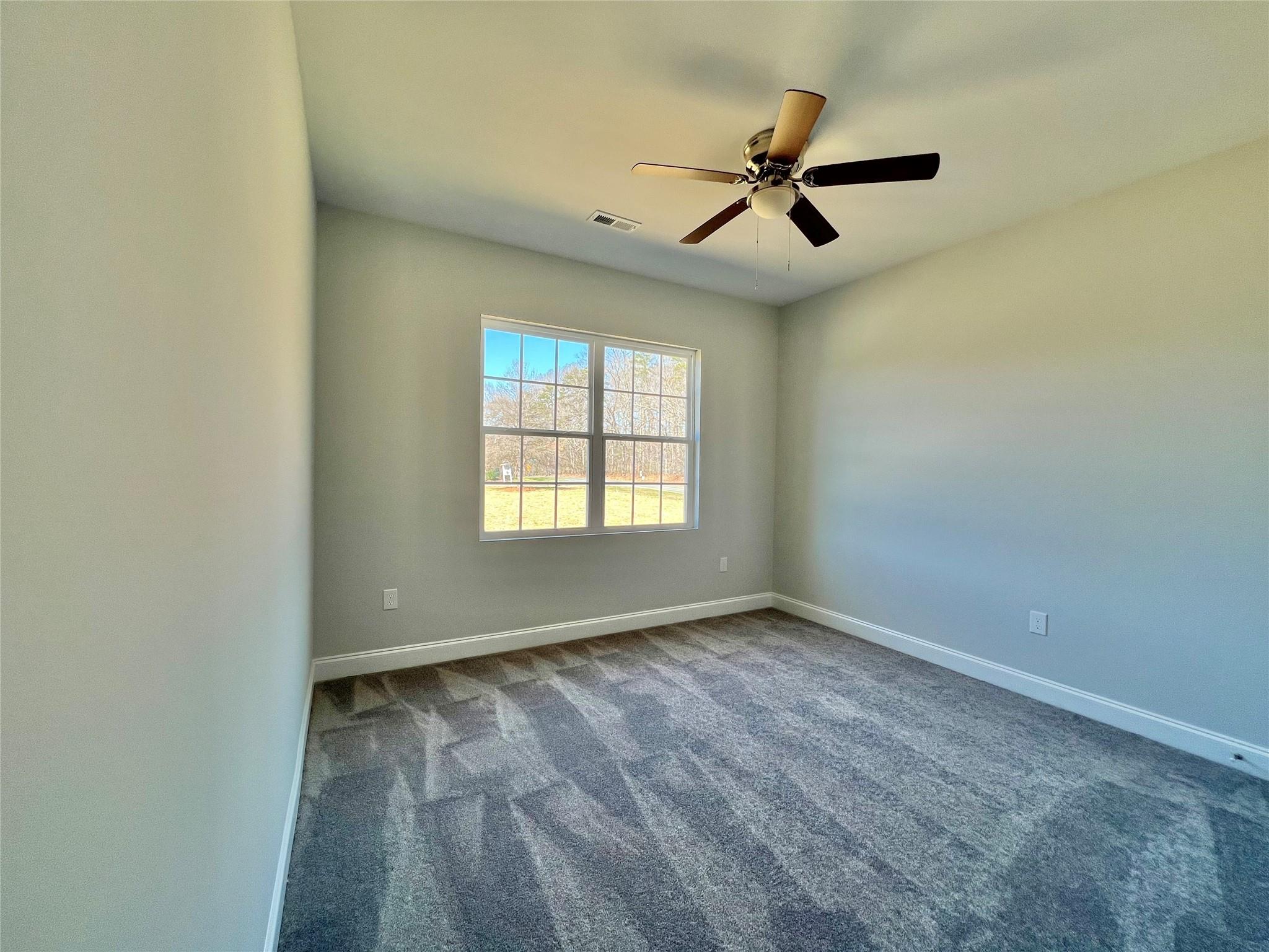 5322 Pond Bluff Drive Monroe, NC 28112 - Photo 18 of 21 an empty room with ceiling fan and windows