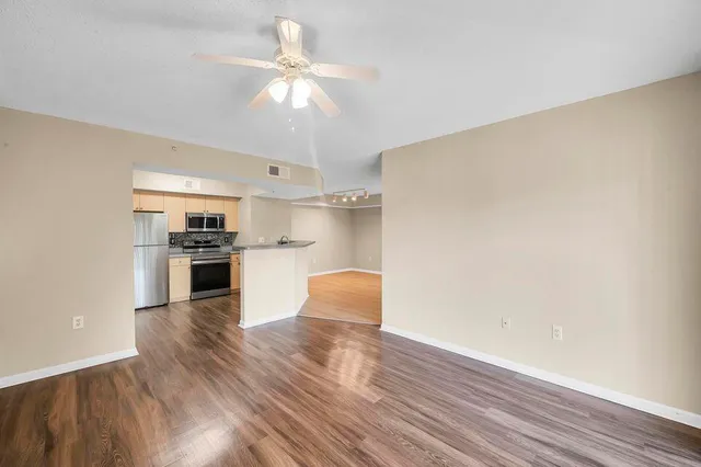 a kitchen with wooden floor and stainless steel appliances