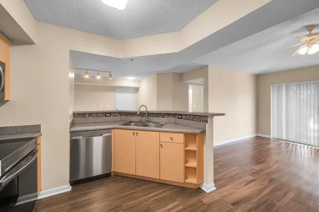 a view of a kitchen with a sink wooden floor and a fireplace