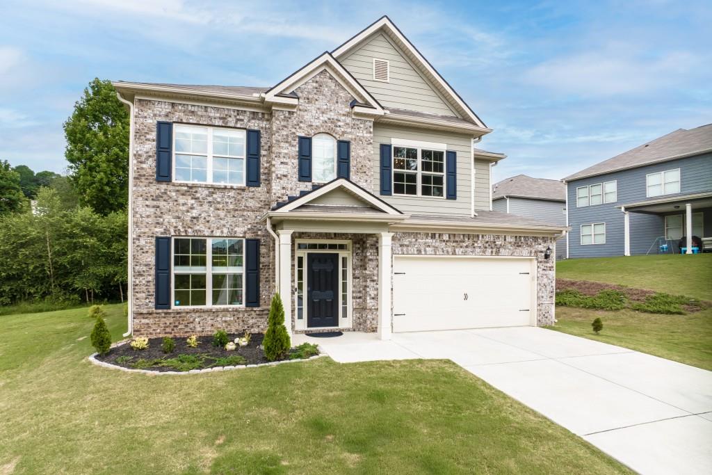 a view of a white house with a yard and potted plants
