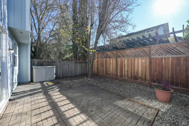a view of a backyard with potted plants and wooden fence