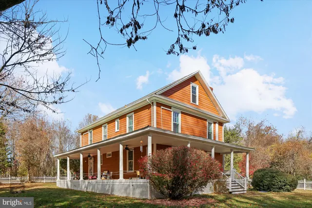 a view of an empty room with wooden floor and window
