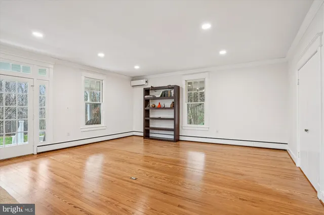 a view of a big room with wooden floor and windows