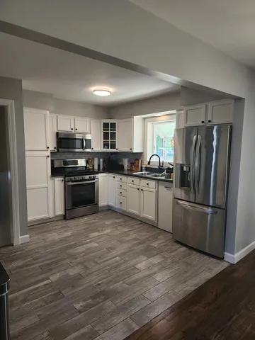 a kitchen with refrigerator a microwave and cabinets