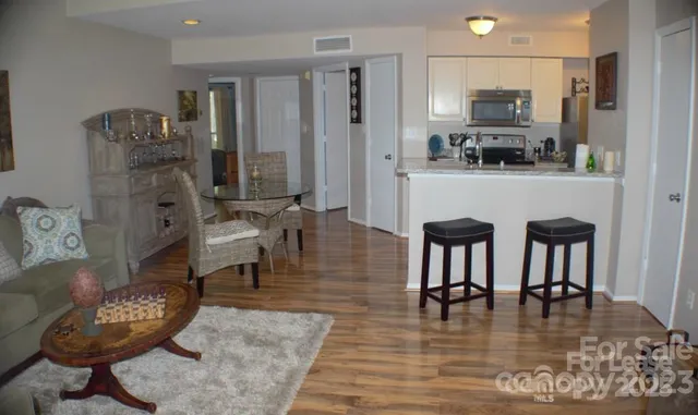a kitchen with stainless steel appliances granite countertop a table chairs and a refrigerator