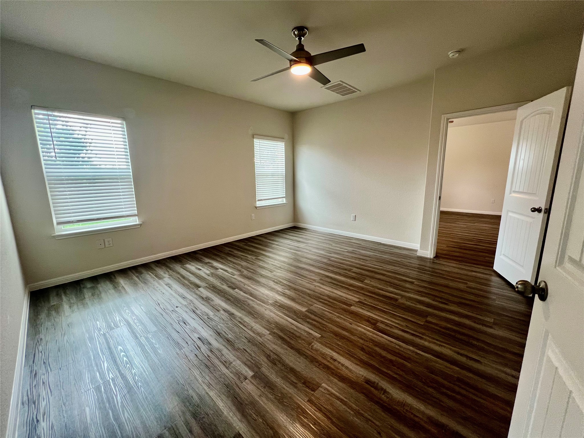 104 Moravia Road Georgetown, TX 78626 - Photo 29 of 36 Well-lit living area showcases rich wood-look flooring and multiple windows, providing a comfortable ambiance.