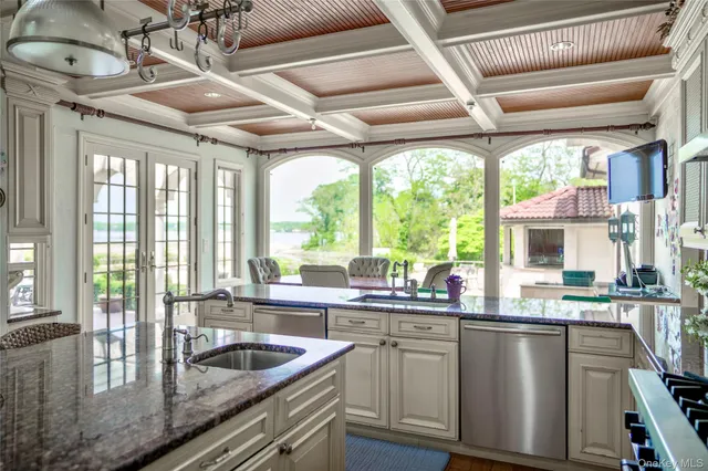 a kitchen with stainless steel appliances granite countertop a sink a counter space cabinets and dining table