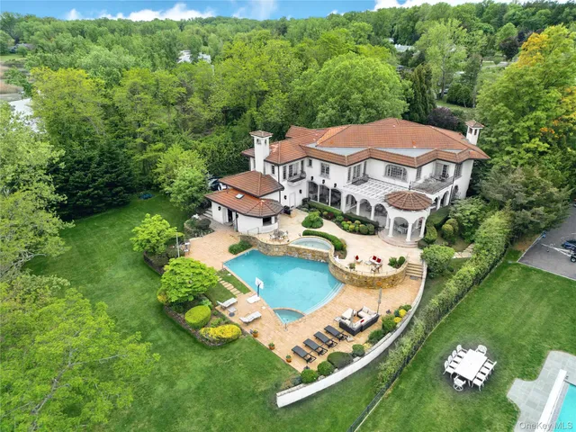 an aerial view of a house with a yard and lake view
