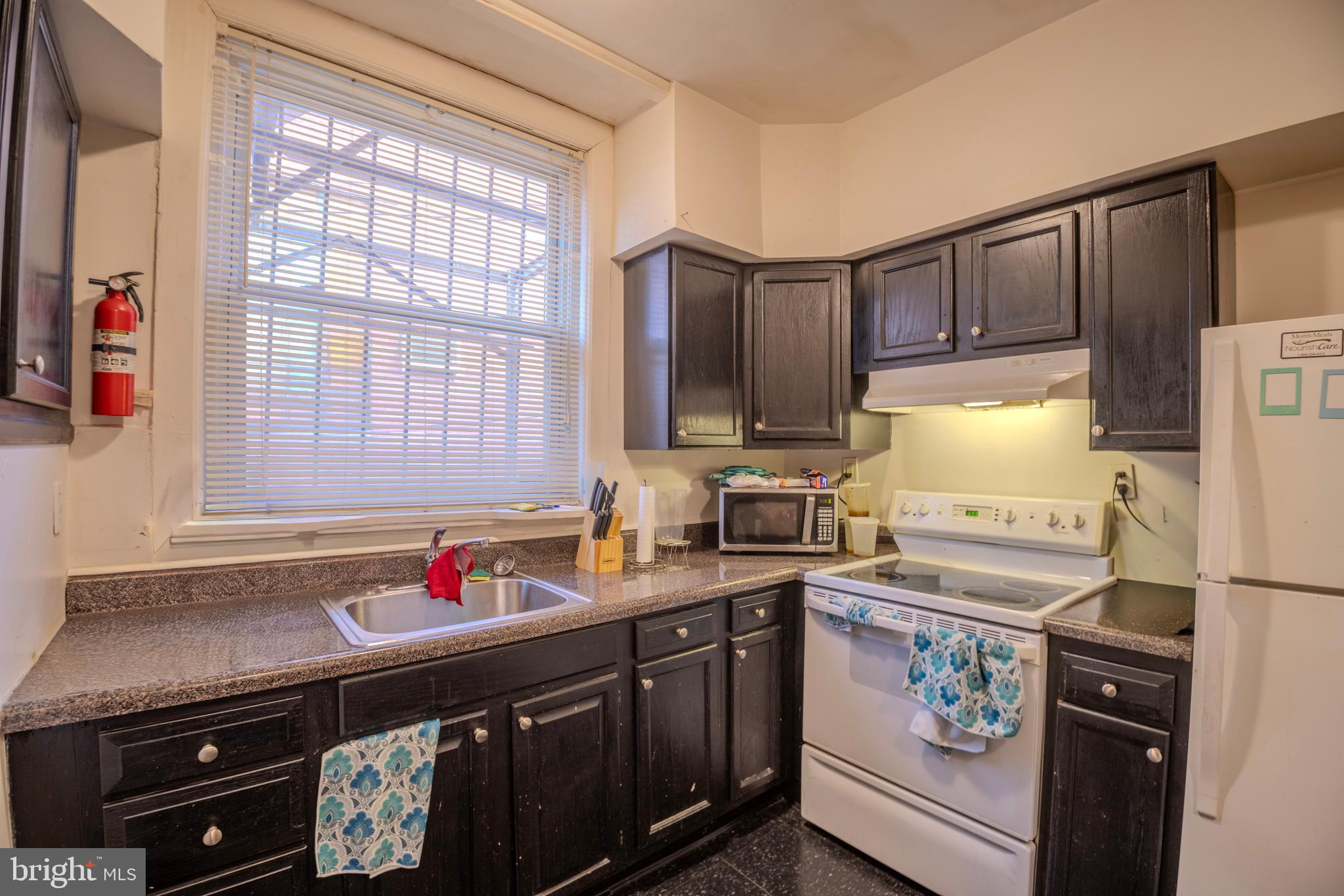 323 West 7th Street Chester, PA 19013 - Photo 11 of 39 a kitchen with granite countertop a sink stove and refrigerator
