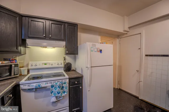 a kitchen with a refrigerator and a stove top oven