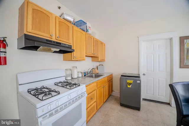a kitchen with stainless steel appliances a stove a sink cabinets and a window
