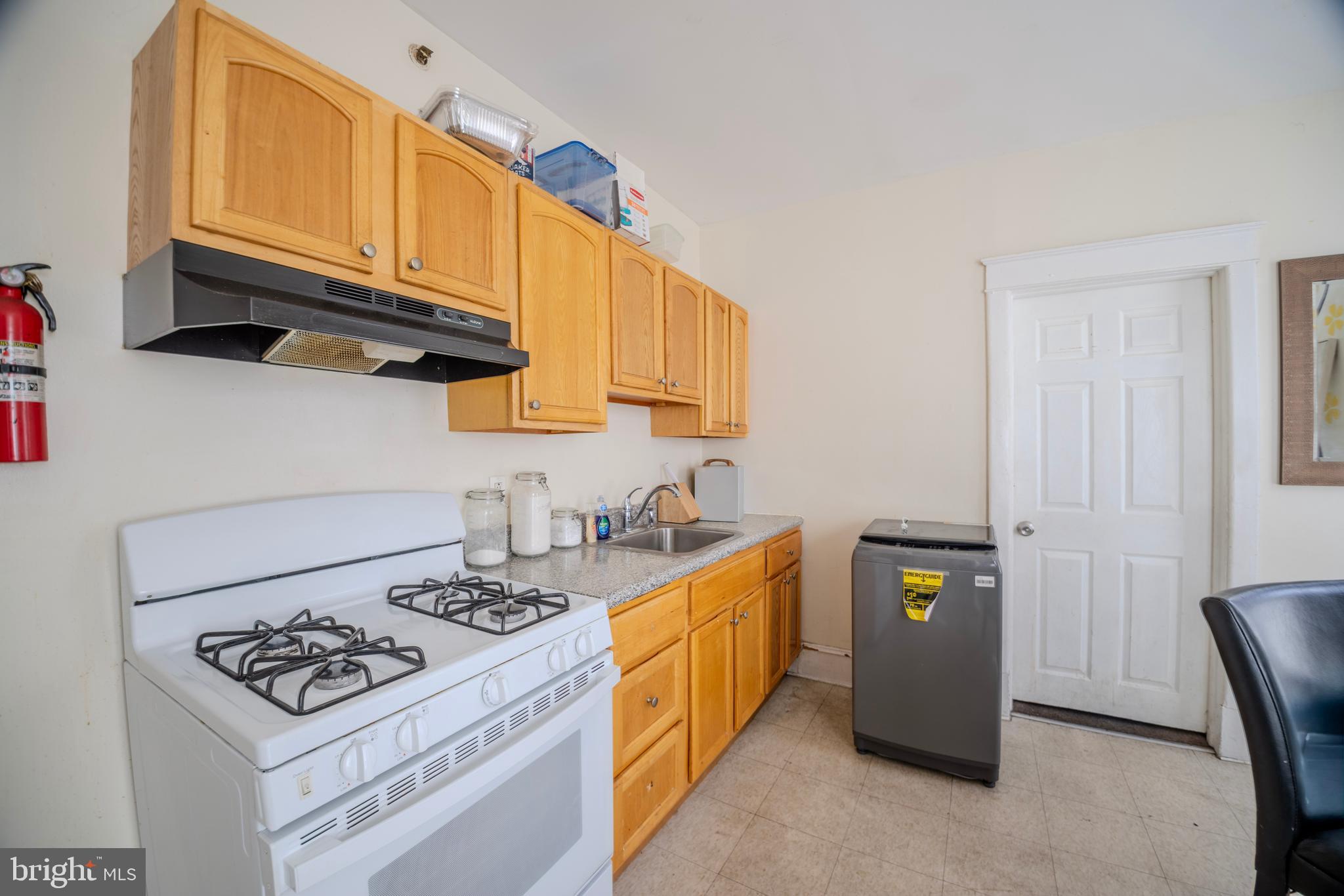 323 West 7th Street Chester, PA 19013 - Photo 17 of 39 a kitchen with stainless steel appliances a stove a sink cabinets and a window