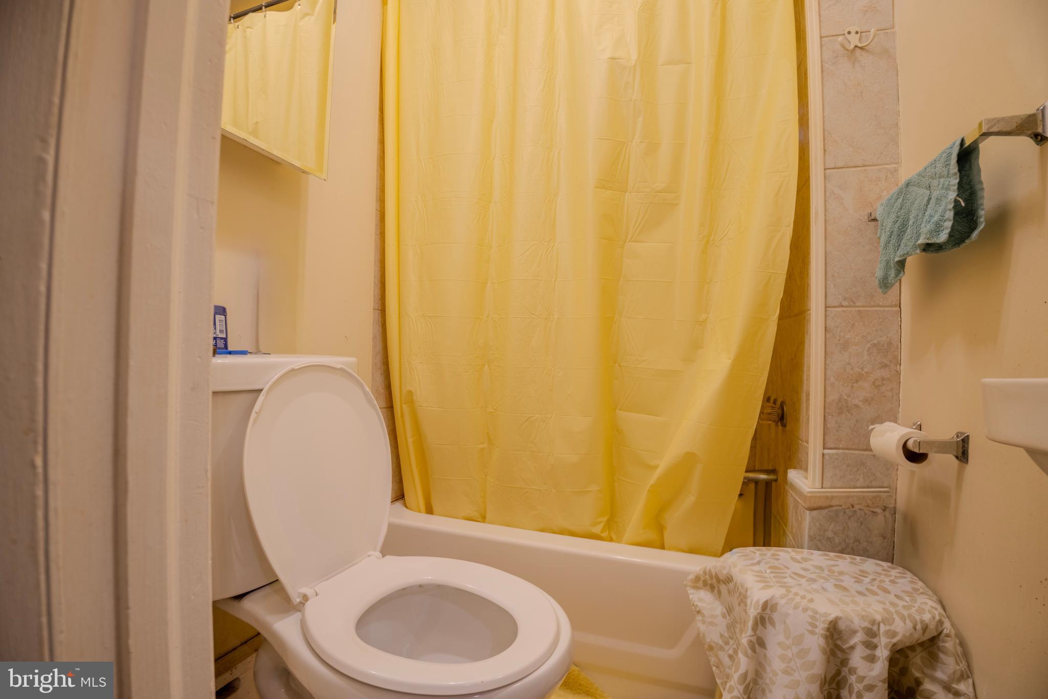 323 West 7th Street Chester, PA 19013 - Photo 32 of 39 a bathroom with a sink a toilet and shower curtain
