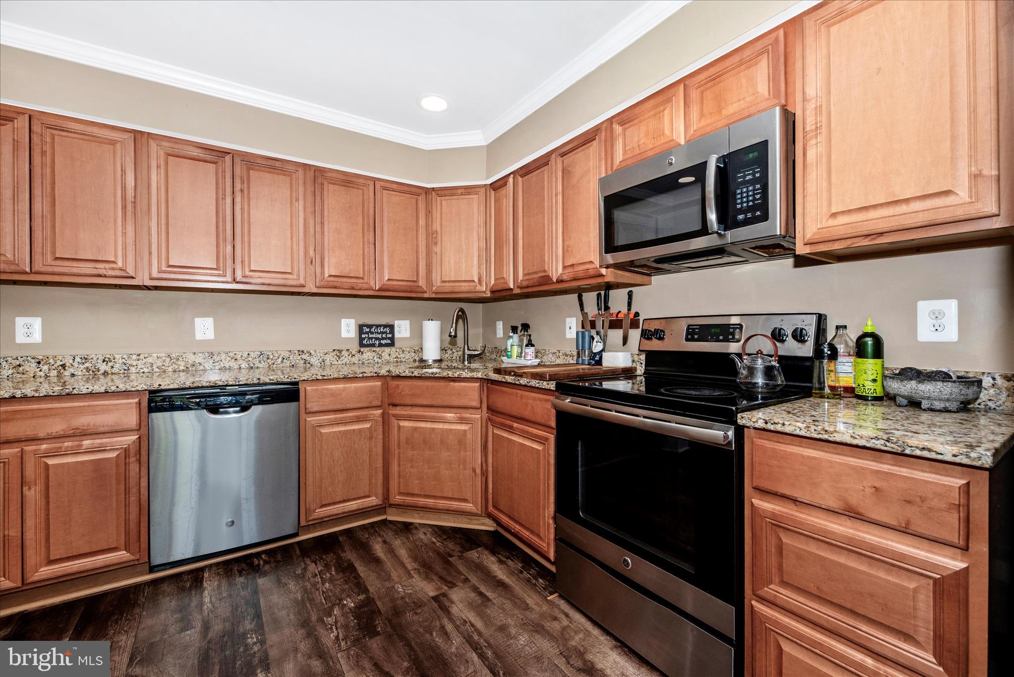 6630 Commodore Court New Market, MD 21774 - Photo 14 of 68 a kitchen with stainless steel appliances granite countertop wooden cabinets a stove a sink and dishwasher with wooden floor