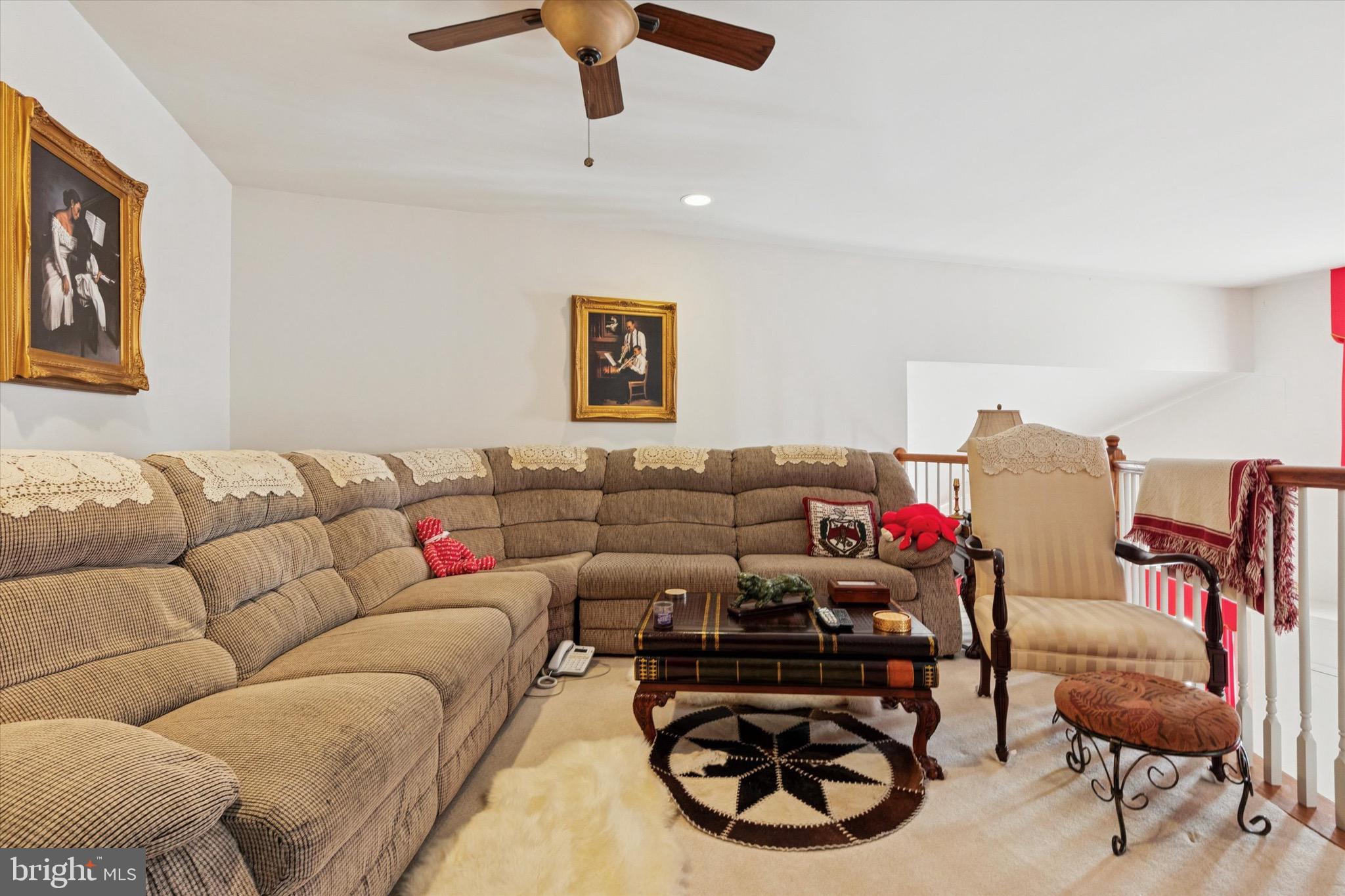3821 Nanlyn Farm Circle Doylestown, PA 18902 - Photo 7 of 24 a living room with furniture a rug and a ceiling fan
