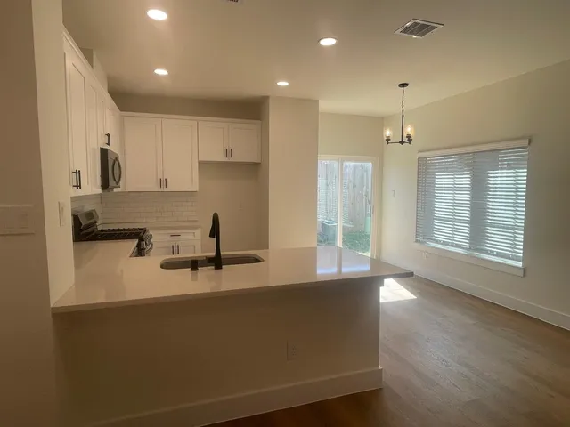 a kitchen with stainless steel appliances granite countertop a sink a stove and a refrigerator