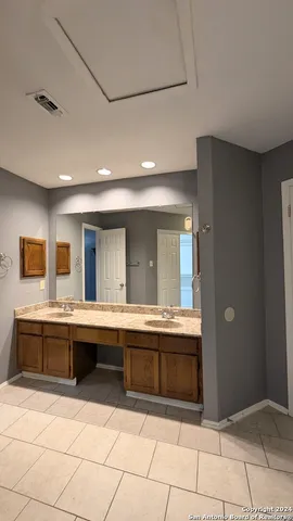 a view of kitchen with stainless steel appliances granite countertop a sink and white cabinets