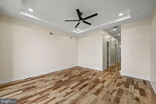 a view of a livingroom with a ceiling fan and wooden floor