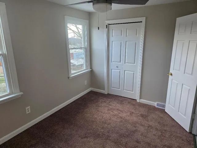 an empty room with windows and closet