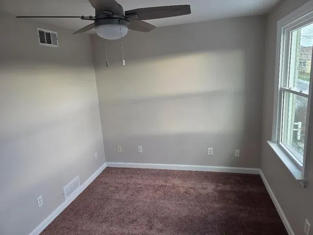 a view of a room with a window and a ceiling fan