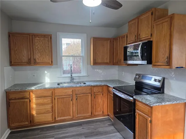 a kitchen with stainless steel appliances granite countertop a sink stove and microwave