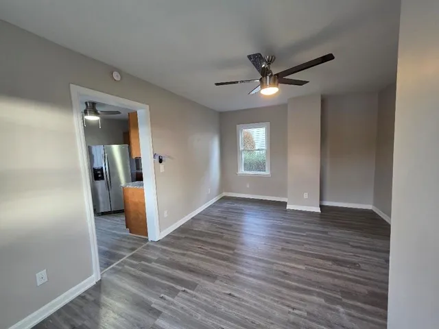 an empty room with wooden floor and windows