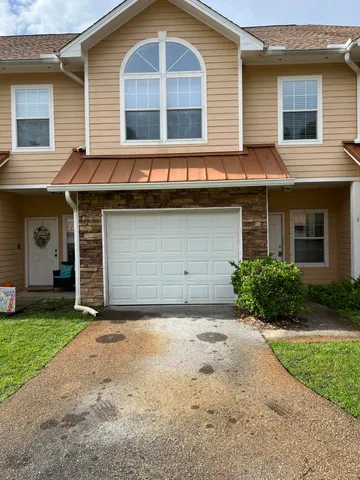 a front view of a house with a garden and garage
