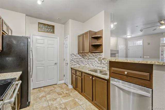 a kitchen with stainless steel appliances granite countertop a refrigerator and a stove top oven