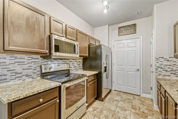 a kitchen with granite countertop a sink stove and refrigerator
