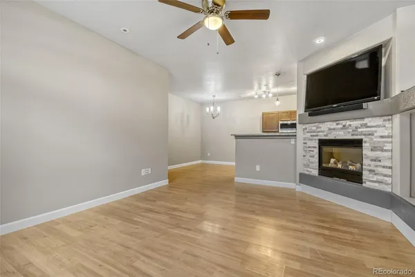 a view of a livingroom with a fireplace a ceiling fan a fireplace and windows