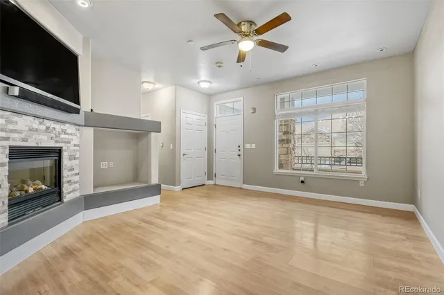 a view of an empty room with a fireplace and a window