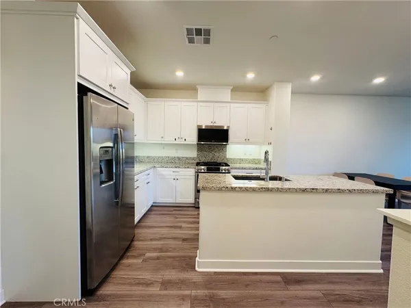 a kitchen with sink refrigerator stove and microwave