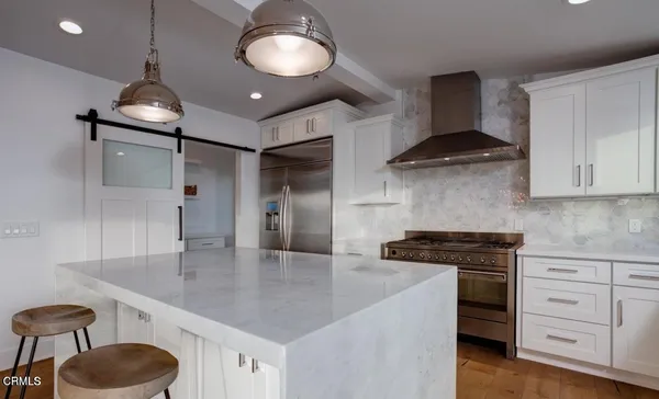 a kitchen with stainless steel appliances granite countertop a sink a stove and cabinets
