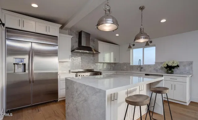 a kitchen with kitchen island a counter space a refrigerator and cabinets