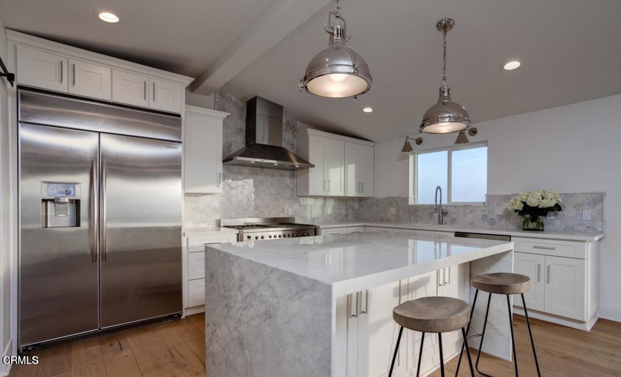 3026 Hilltop Drive Ventura, CA 93003 - Photo 5 of 31 a kitchen with kitchen island a counter space a refrigerator and cabinets