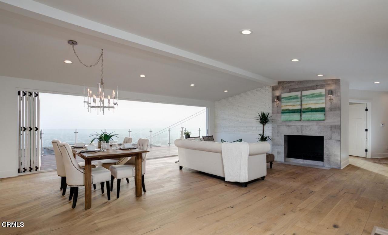 3026 Hilltop Drive Ventura, CA 93003 - Photo 6 of 31 a living room with furniture a fireplace and a dining table with kitchen view