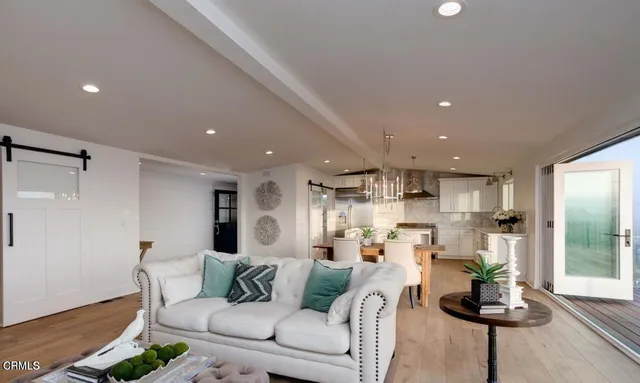 a living room with furniture and a view of kitchen