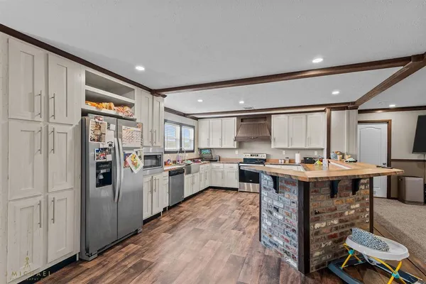 a kitchen with cabinets and wooden floor