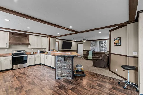 a large white kitchen with a large window and stainless steel appliances